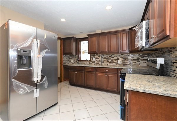 24 Elm Street Boston, MA 02136 - Photo 3 of 27 a kitchen with stainless steel appliances granite countertop a sink stove and refrigerator