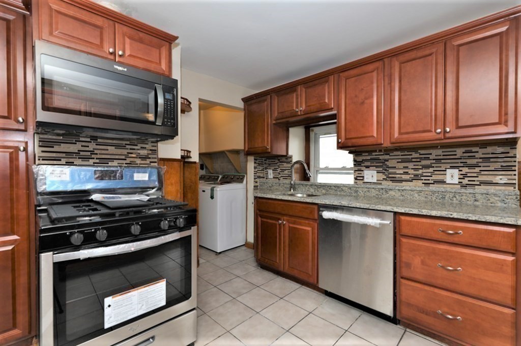 24 Elm Street Boston, MA 02136 - Photo 4 of 27 a kitchen with granite countertop a stove and a microwave