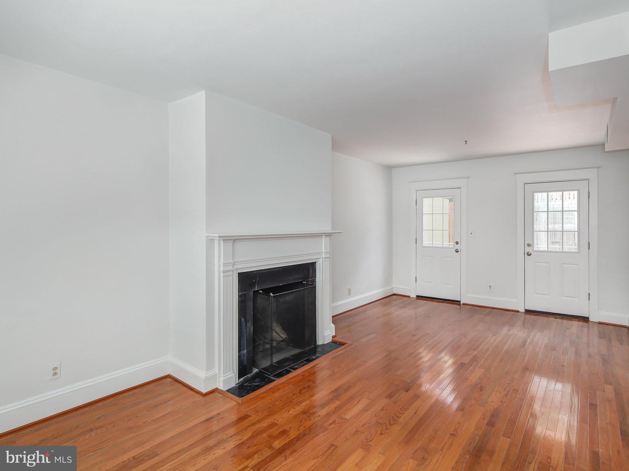 1920 35th Place Northwest Washington, DC 20007 - Photo 9 of 30 a view of empty room with wooden floor and fireplace