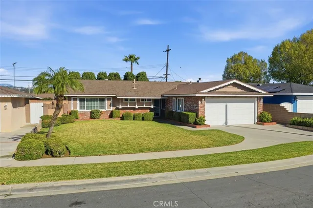 a front view of a house with a yard and potted plants