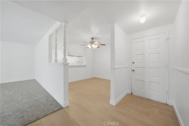 an empty room with a window and ceiling fan