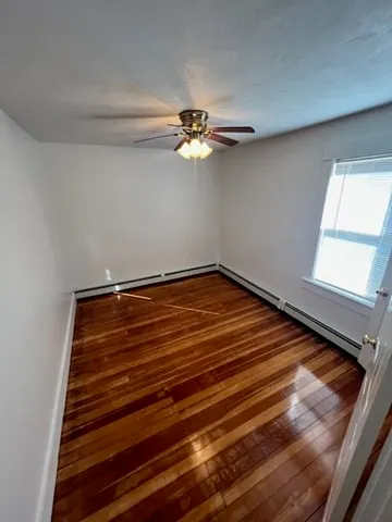a room with a chandelier fan and windows