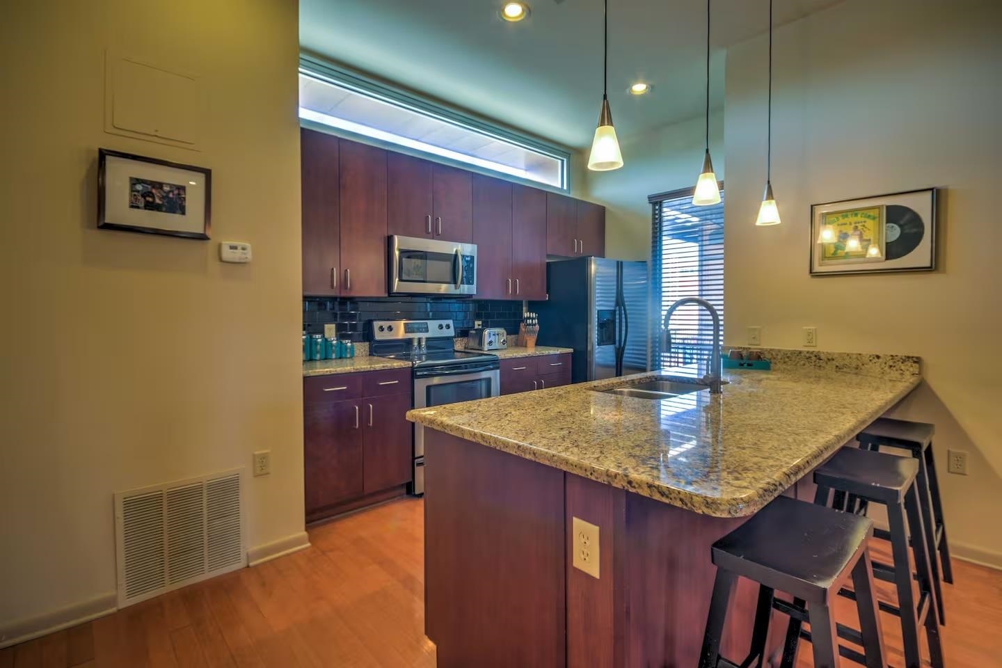 449 Monroe Avenue, Unit 115 Memphis, TN 38103 - Photo 4 of 35 a kitchen with stainless steel appliances granite countertop a sink a microwave counter and chairs