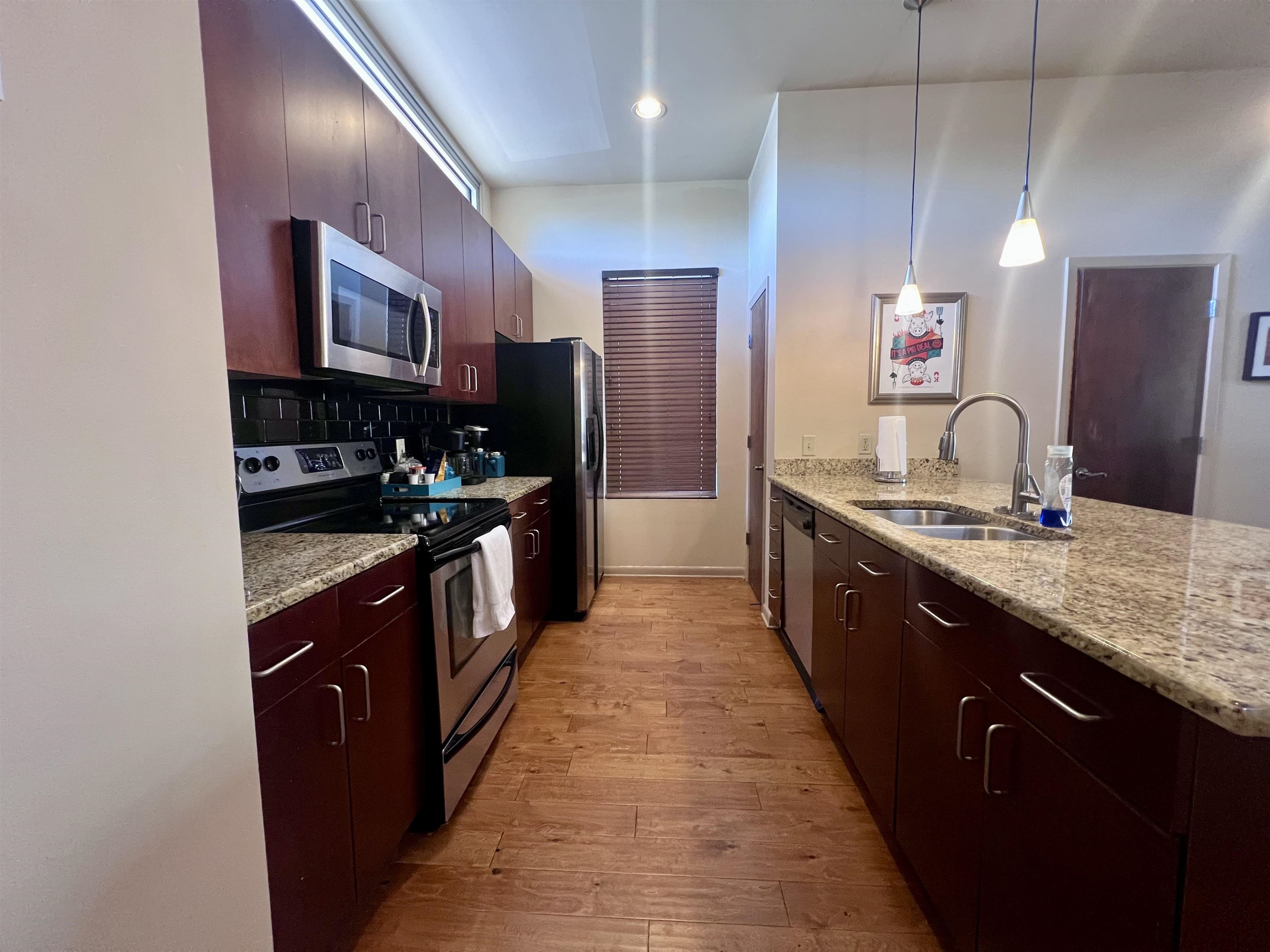 449 Monroe Avenue, Unit 115 Memphis, TN 38103 - Photo 7 of 35 a large kitchen with stainless steel appliances kitchen island granite countertop a large counter top and a sink