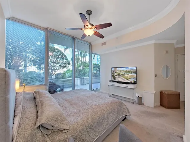 a bedroom with bed tv and view