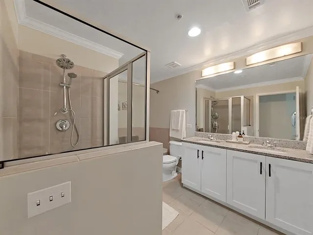 a bathroom with a granite countertop sink a toilet and a large mirror