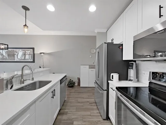 a view of a hallway with wooden floor and closet