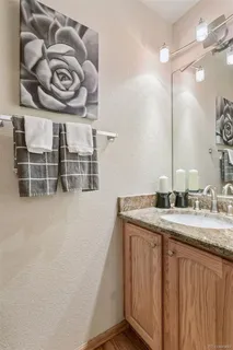 a bathroom with a granite countertop sink a vanity and a shower
