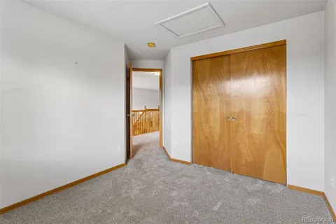 a view of an empty room with closet and a window