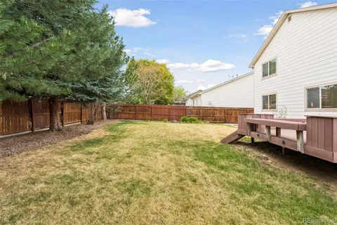 a backyard of a house with barbeque oven table and chairs