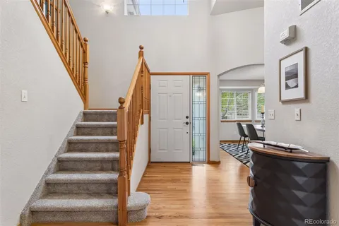 a view of a hallway with wooden floor and staircase