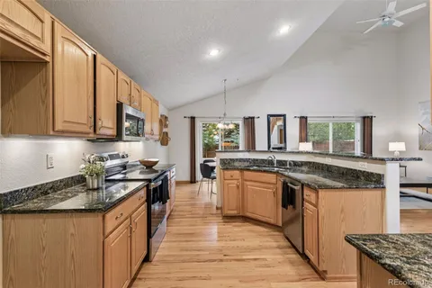 a kitchen with granite countertop stainless steel appliances and wooden cabinets