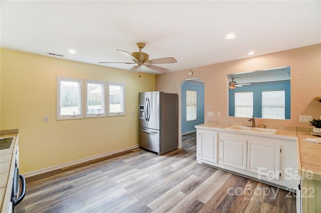 1813 Medlin Road Monroe, NC 28112 - Photo 8 of 45 a large room with chandelier fan and wooden floor