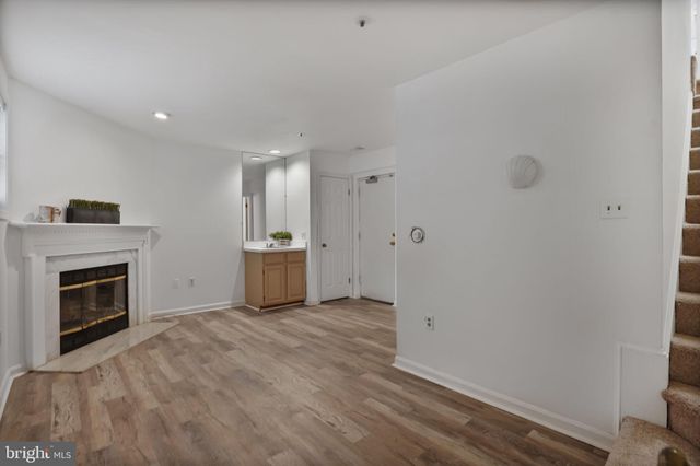 a view of a kitchen with a sink wooden cabinet and fireplace