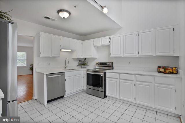 a kitchen with white cabinets appliances and a sink