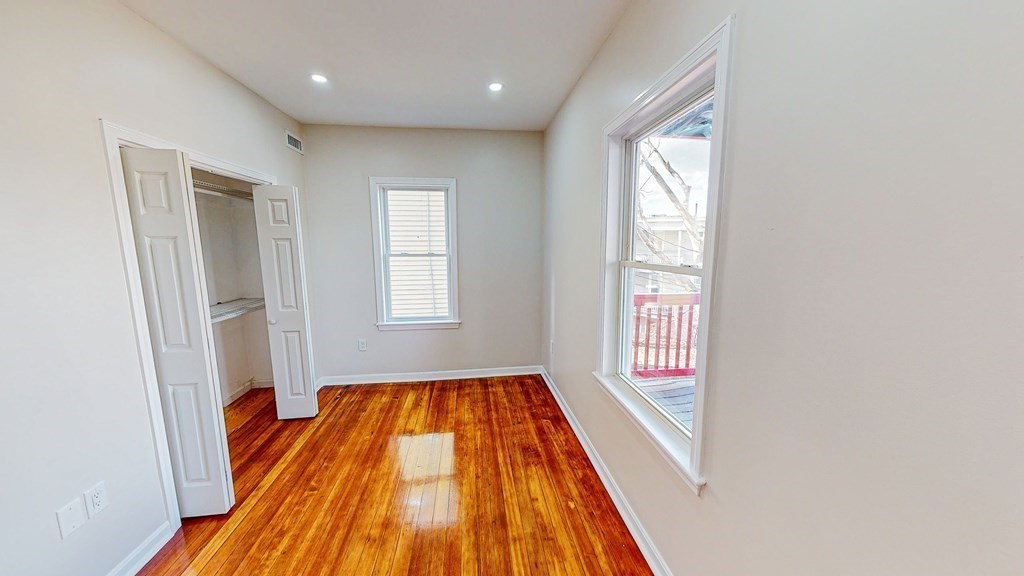 109 Deering Road, Unit 1 Boston, MA 02126 - Photo 11 of 12 a view of a hallway with wooden floor and staircase