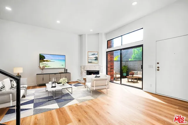 a living room with furniture large window and a table