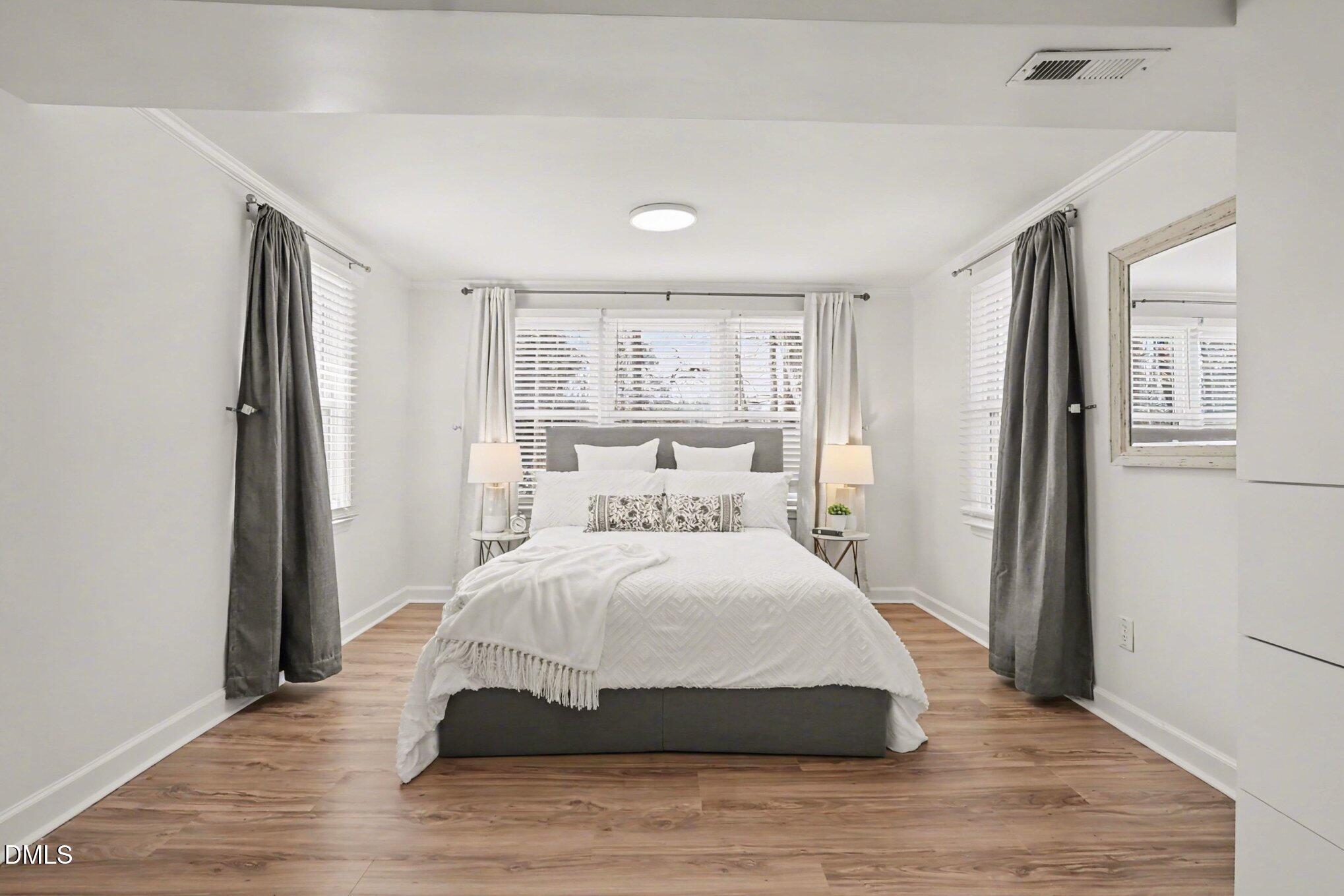 3043 Creech Road Garner, NC 27529 - Photo 14 of 38 a spacious bedroom with a bed and wooden floor