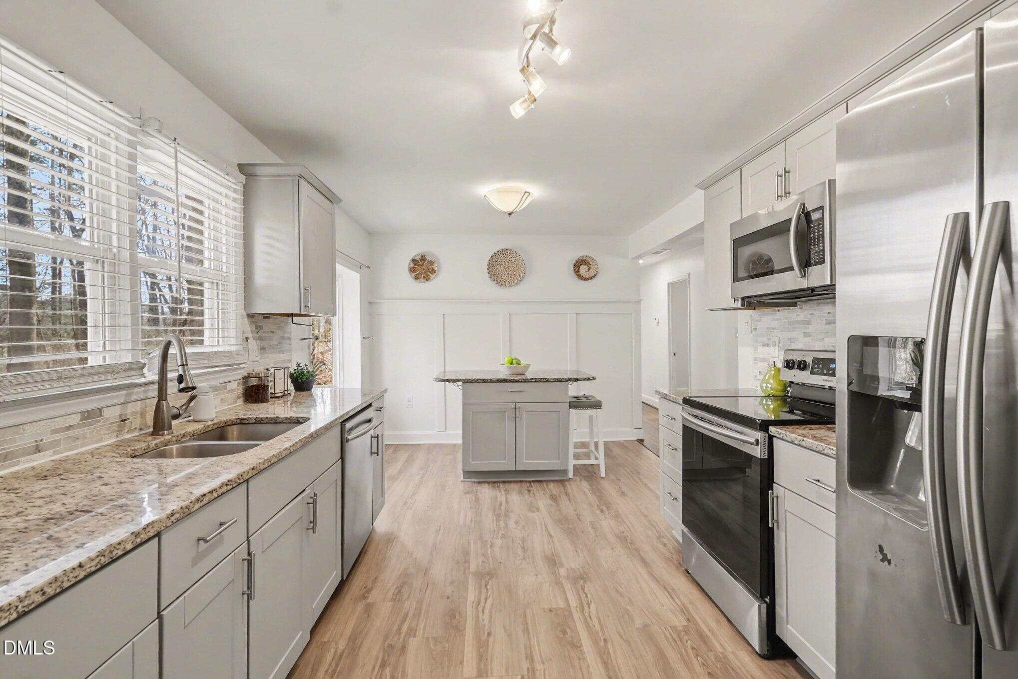 3043 Creech Road Garner, NC 27529 - Photo 9 of 38 a large kitchen with stainless steel appliances lots of counter space and a sink