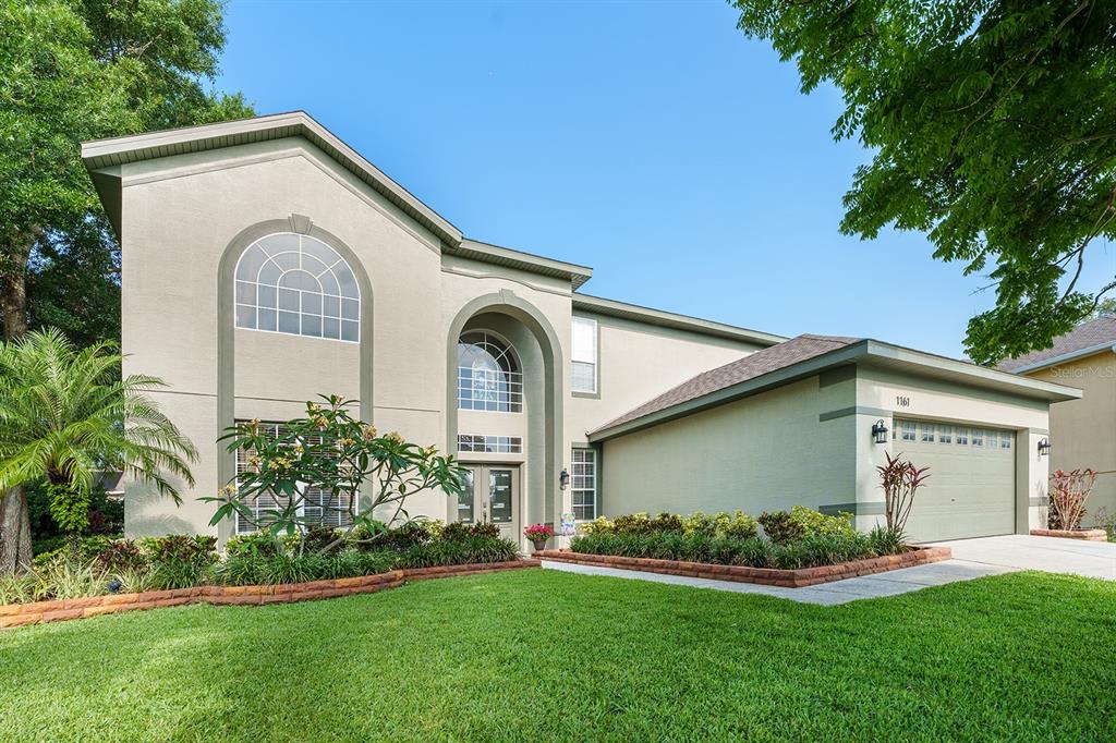 a front view of a house with a garden and plants