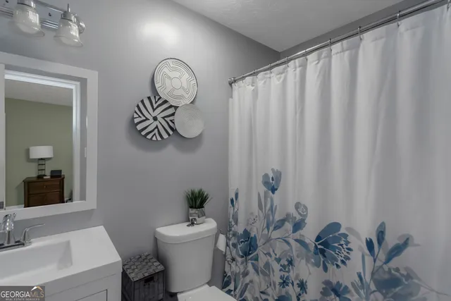 a bathroom with a toilet a sink and a mirror