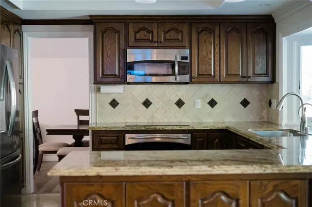 a kitchen with stainless steel appliances granite countertop a sink and a microwave