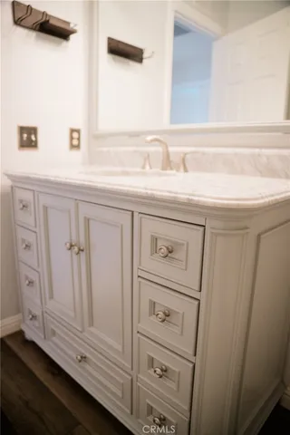 a bathroom with a granite countertop sink a toilet and a mirror