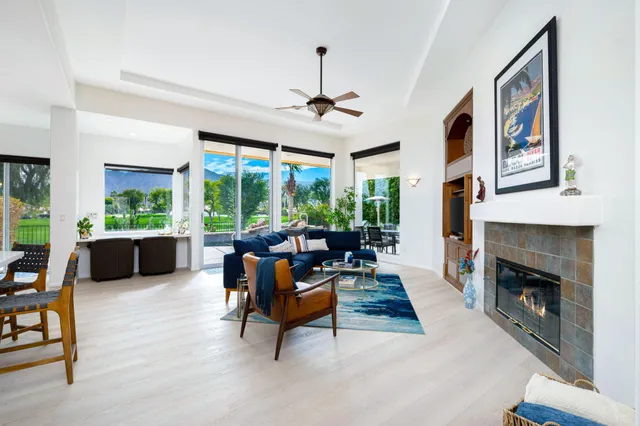 a living room with furniture a fireplace and a floor to ceiling window