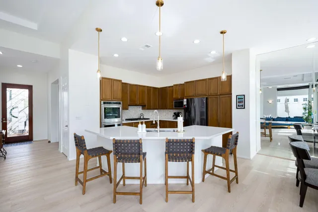 a kitchen with a table chairs refrigerator and cabinets