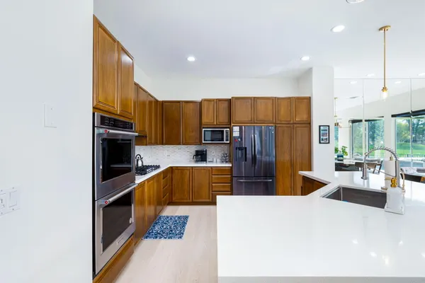 a kitchen with stainless steel appliances kitchen island granite countertop a refrigerator and stove