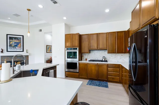 a kitchen with stainless steel appliances granite countertop a refrigerator stove microwave and sink