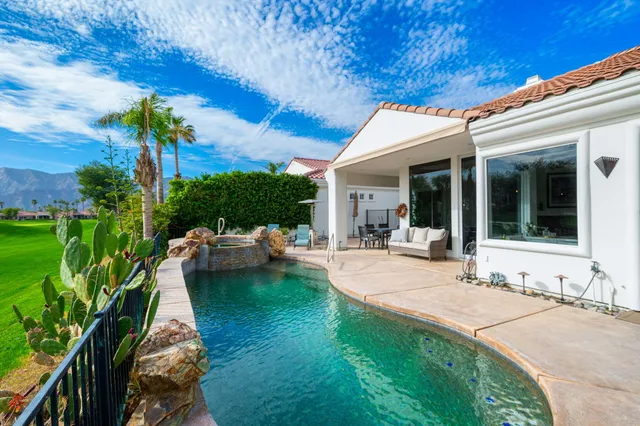 a view of a patio with couches table and chairs and potted plants