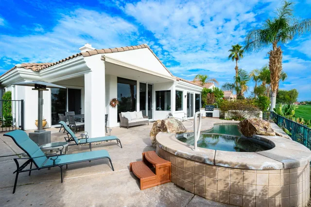 a view of a house with swimming pool and sitting area