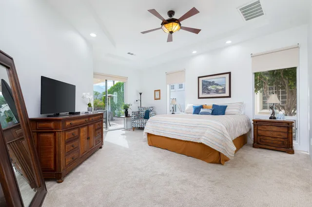 a spacious bedroom with a bed and a flat screen tv