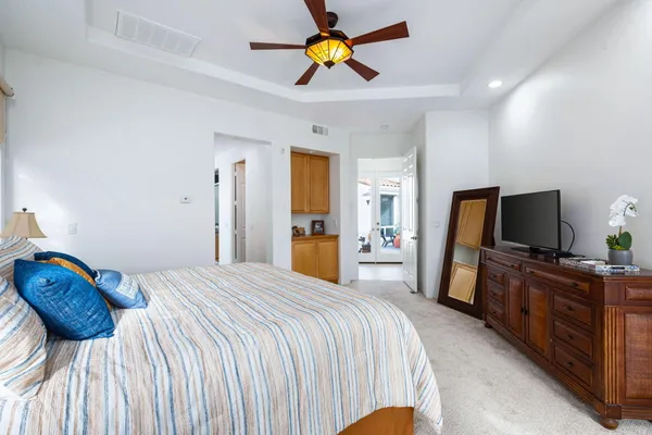 a bedroom with a bed and a flat tv screen on the dresser