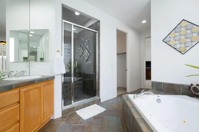 a bathroom with a tub sink and mirror
