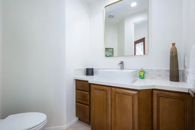 a bathroom with a granite countertop sink and a mirror