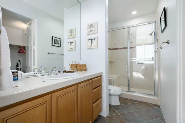 a bathroom with a granite countertop sink toilet and shower