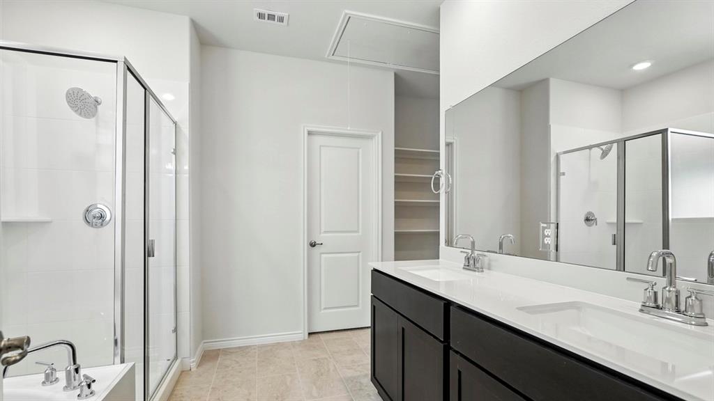 4159 Waldron Trail Forney, TX 75126 - Photo 15 of 19 Bathroom featuring a glass-enclosed shower, a double vanity with ample counter space, and integrated shelving