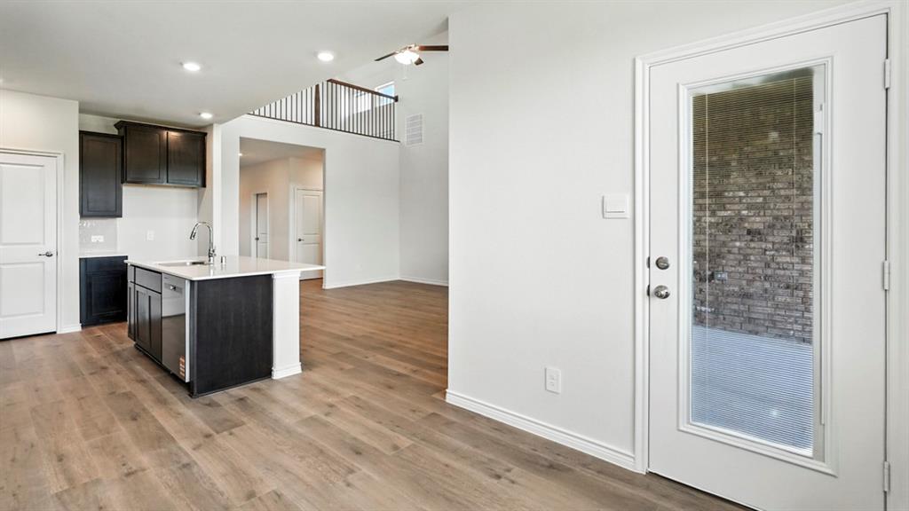 4159 Waldron Trail Forney, TX 75126 - Photo 6 of 19 Open-concept living area featuring light wood flooring and a kitchen island with a sink