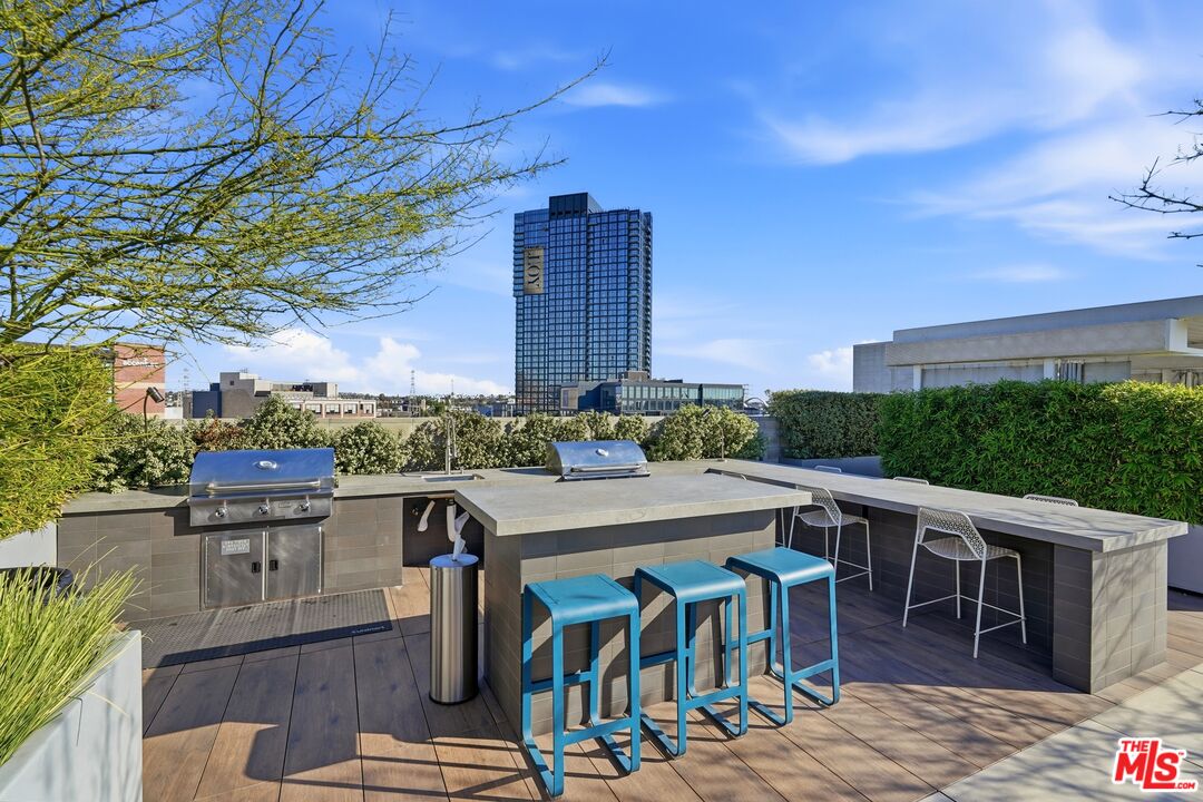 530 South Hewitt Street, Unit 533 Los Angeles, CA 90013 - Photo 37 of 57 a view of a patio with table and chairs potted plants with wooden floor and fence