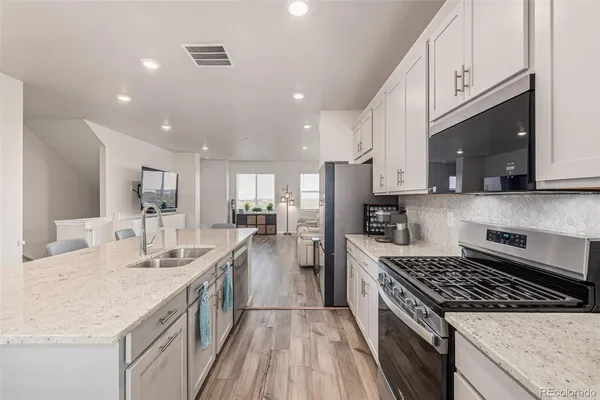 a kitchen with stainless steel appliances kitchen island granite countertop a stove a sink and a microwave