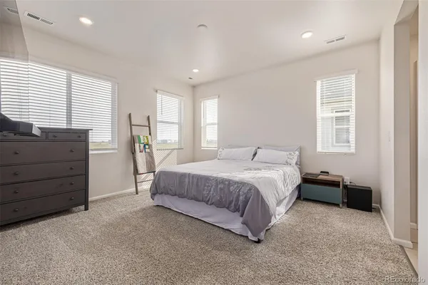 a spacious bedroom with a bed and a dresser