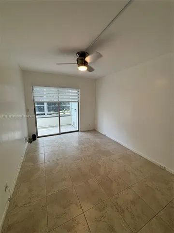 an empty room with windows and ceiling fan