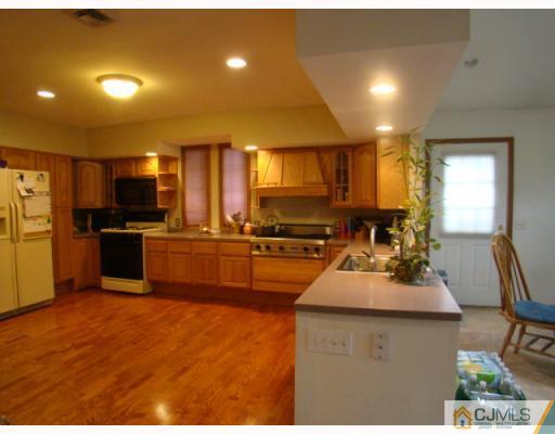 26 Stiles Road Edison, NJ 08817 - Photo 3 of 9 a kitchen with sink a refrigerator and chairs