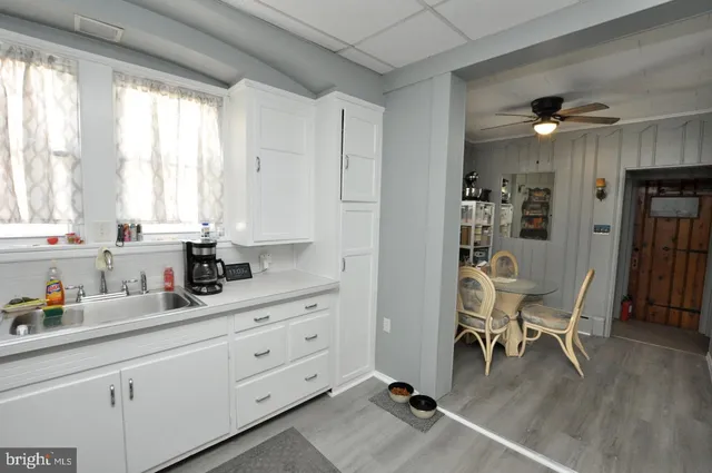 a kitchen with stainless steel appliances kitchen island granite countertop a table chairs refrigerator and cabinets