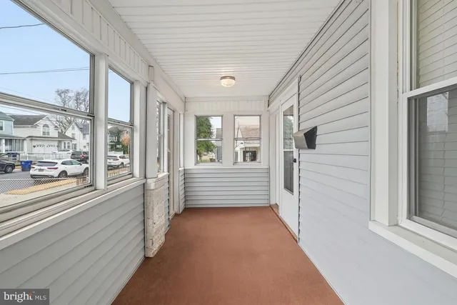 a view of a porch with wooden floor and windows