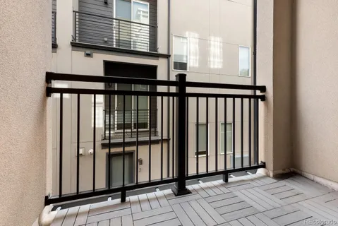 a kitchen with stainless steel appliances a refrigerator a stove a sink a dining table and chairs with wooden floor