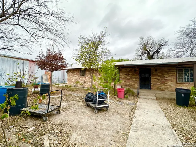 a view of a chairs and table in the back yard of the house