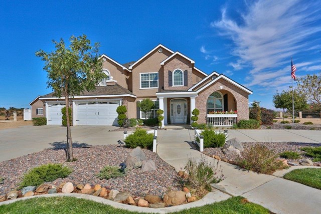 9950 Ranchero Road Oak Hills, CA 92344 - Photo 1 of 1 a front view of a house with garden